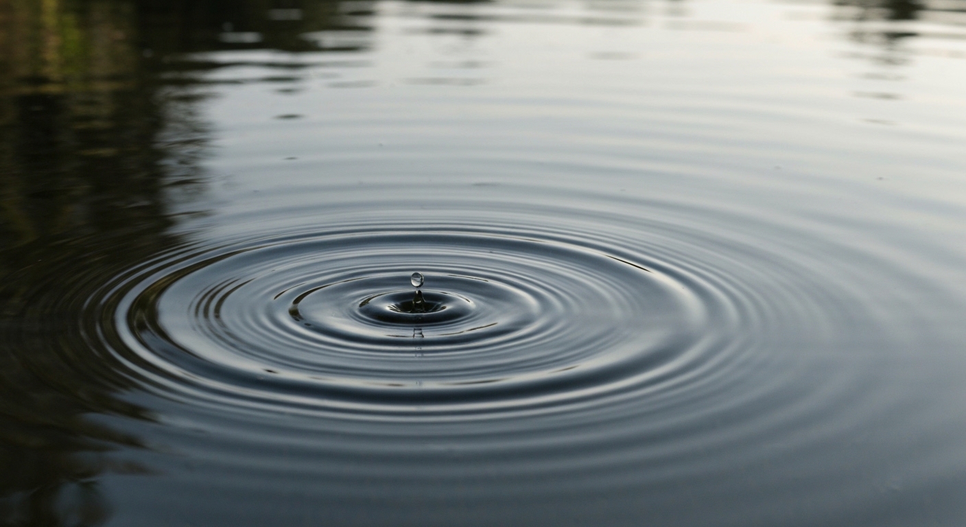 A perfectly still, reflective surface of dark, calm water, with the subtle, outward ripples from a single, barely perceptible drop expanding gently without disturbance. The scene conveys profound, unforced tranquility and a sense of vast, undisturbed space.